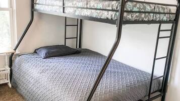 Un lit superposé avec un matelas à motifs, un oreiller et une structure en métal.