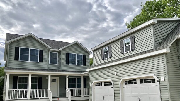 A two-story house with a covered porch, two garages, and a gravel driveway. - Beautiful, recently built 6BR/ 4BA Home in Narragansett Pier!!! (Narragansett)