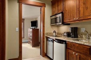 Kitchen features a microwave, kettle, and granite countertop.