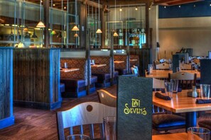 Enjoy casual dining in a restaurant with booths and tables, a chalkboard menu, and pendant lighting.
