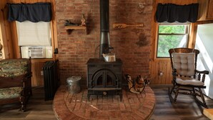 A cozy room with a brick fireplace, a rocking chair, and a vintage sofa.