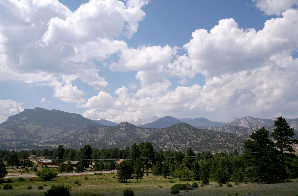 A mountainous landscape with a clear sky and scattered clouds.