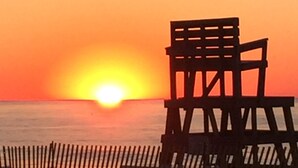 Una sedia a sdraio con vista sull'oceano al tramonto.