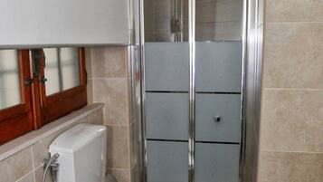 A bathroom with a toilet, bidet, and shower stall.