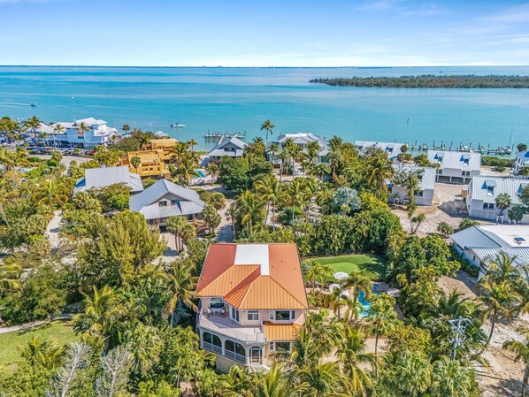A coastal residential area with houses, a swimming pool, and a view of the ocean.