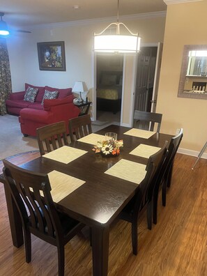 Un coin repas avec une table en bois, des chaises et un centre de table floral.