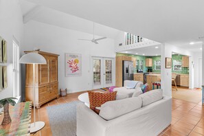 A modern living room with a sofa, a wooden cabinet, and a ceiling fan.