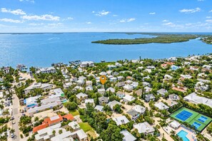 Un quartier résidentiel situé sur la côte, avec des maisons, un port de plaisance et une vue dégagée sur l’océan.