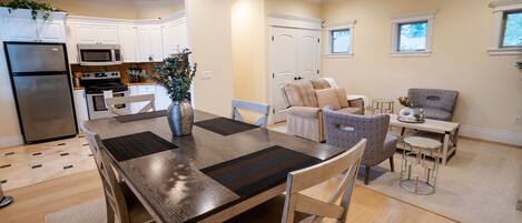 A modern kitchen with white cabinets, a stainless steel refrigerator, and a built-in microwave.