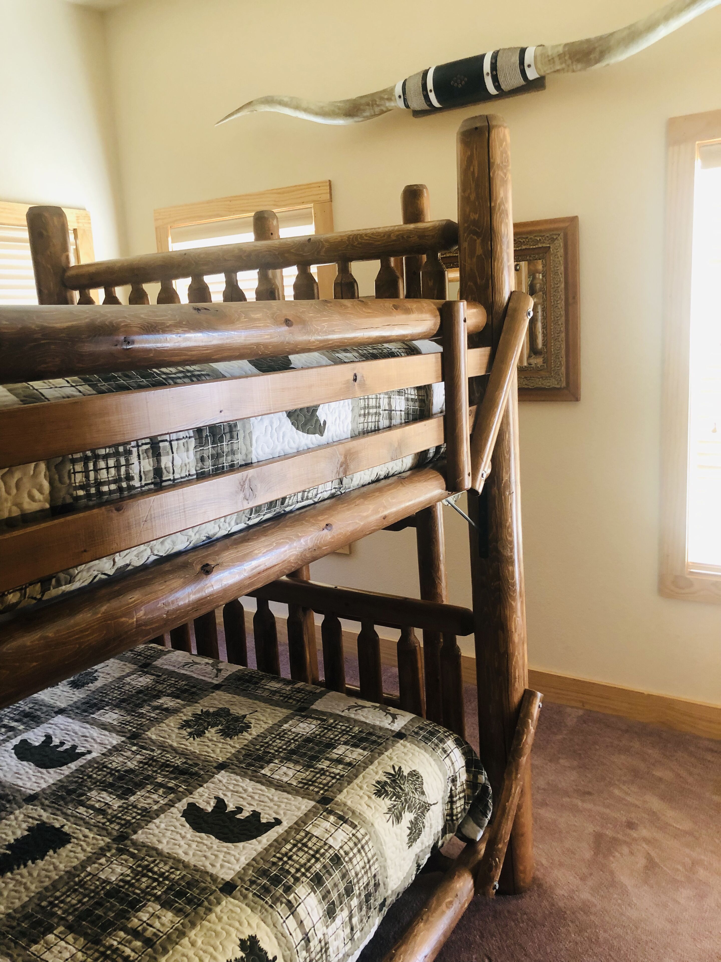 Un banc en bois avec un coussin matelassé, une tête de lit en bois sculptée et un cornet décoratif.