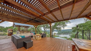An outdoor deck with a wooden pergola, seating area, and a view of a lake. - Lake Travis Waterfront with Resort Style Pool and Million Dollar Views. (Marble Falls)