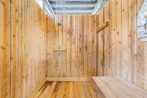 Una sauna con paredes de madera y un banco.