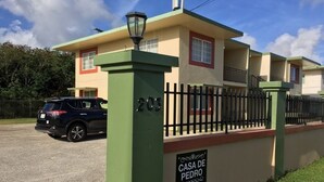 Un immeuble résidentiel portant une enseigne indiquant : « CASA DE PEDRO, 203, Washington Dr., Mangilao, Guam ».
