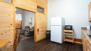 Une cuisine compacte équipée d’un réfrigérateur, d’un four à micro-ondes et d’un petit chariot.