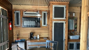 A compact kitchen with a microwave, coffee maker, and a small refrigerator. There is a dining table with chairs and a small rug. - 5 Cabins at The Lazy Buffalo, Wichita Mountains Cache Lawton Fort Sill sleeps 16 (Cache)