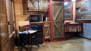 A rustic kitchen with wooden walls, a microwave, a coffee maker, and a small table with a plaid tablecloth. - 5 Cabins at The Lazy Buffalo, Wichita Mountains Cache Lawton Fort Sill sleeps 16 (Cache)