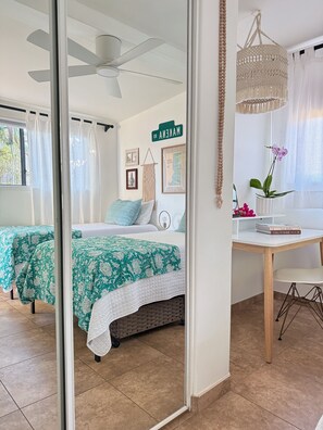 Ein Schlafzimmer mit zwei Betten, einem Schreibtisch, einer hängenden Makramee-Lampenschirm und einem Wandschild mit der Aufschrift 'MACKENZ'.