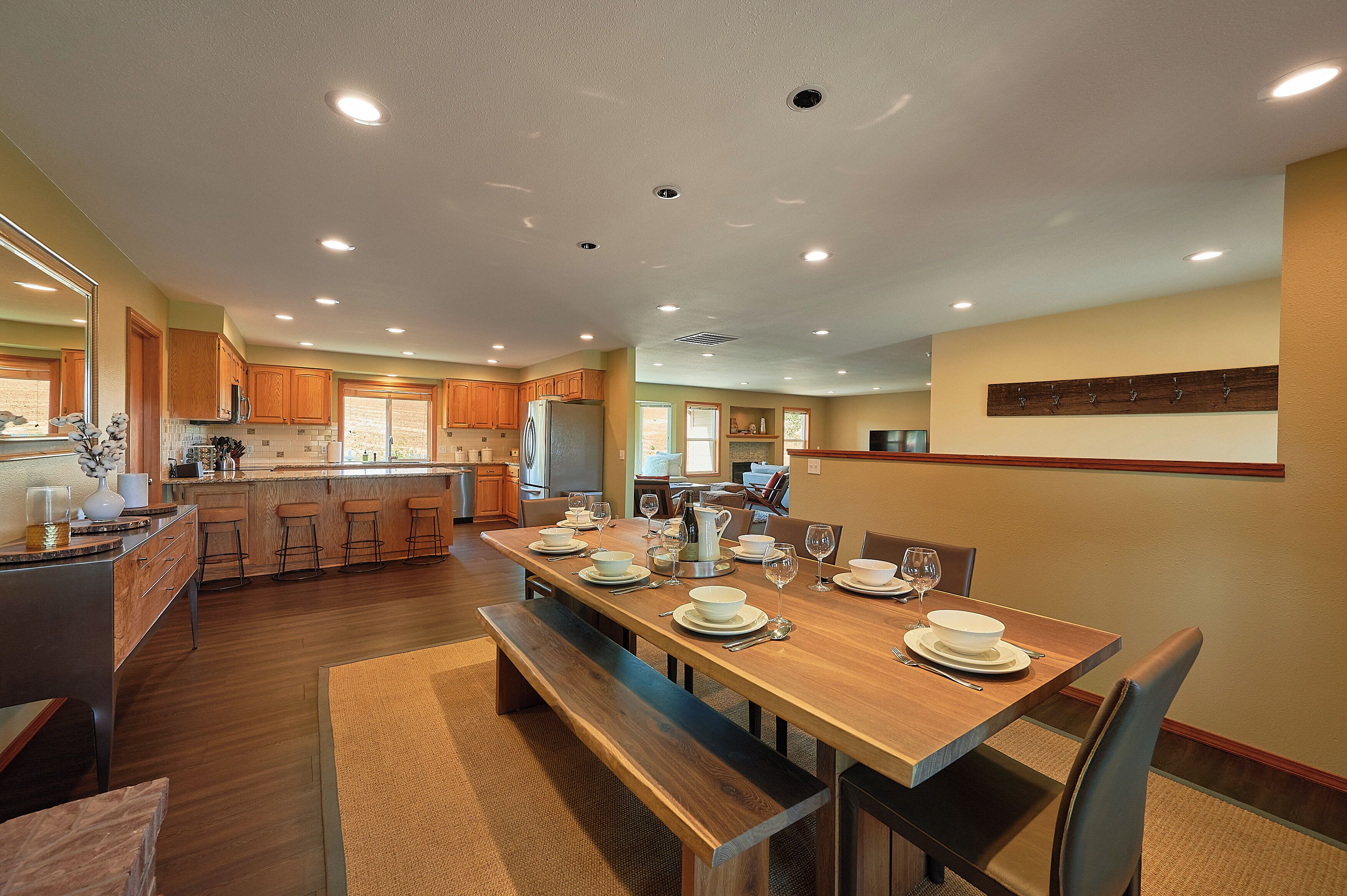 Una cocina amplia con armarios de madera, una isla central y un comedor preparado para seis personas.