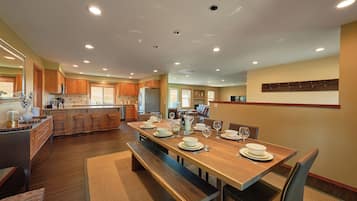 Una cocina amplia con armarios de madera, una isla central y un comedor preparado para seis personas.