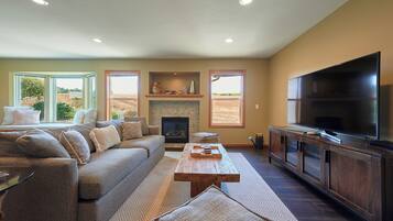 Una sala de estar con sofá, mesa de centro, chimenea y televisor.