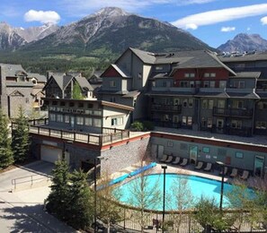 A lodge with a pool, surrounded by mountains.