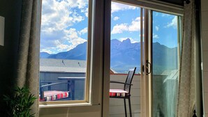 Ein Zimmer mit einer Schiebetür und einem Balkon mit Blick auf die Berge.