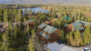 A lodge with multiple cabins surrounded by dense forest and a lake, set against a backdrop of mountains. - Lakeside Mountain Retreat with HOT TUB! (Grand Lake)