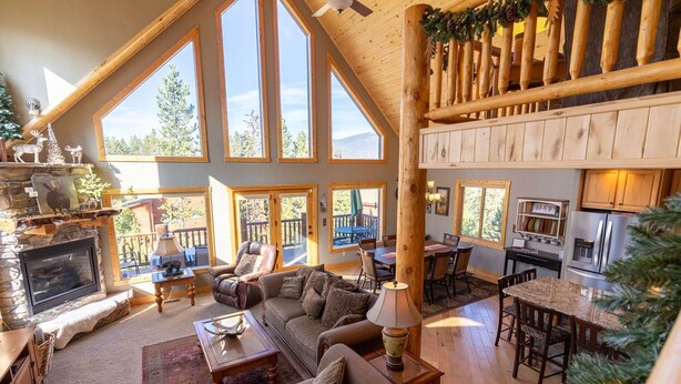 A spacious lodge with a large living area, a fireplace, and a dining area with a view of the mountains. - Lakeside Mountain Retreat with HOT TUB! (Grand Lake)