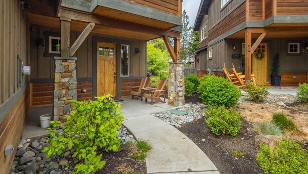 A wooden cabin-style building with a stone foundation, wooden deck, and outdoor seating area. - Golf Views, Game Room & Suncadia Pool Access (Cle Elum)