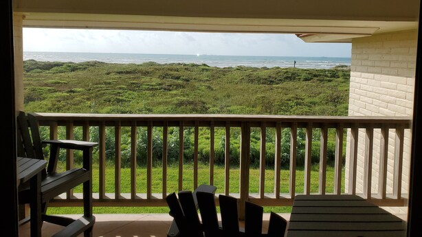 Un balcone con vista sull'oceano e su un paesaggio erboso.
