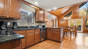 A spacious kitchen with wooden cabinets, granite countertops, and a central island. - Bottoms Up double deck dock w/ slide, hot tub, near famous 'jumping bridge' (LaFollette)