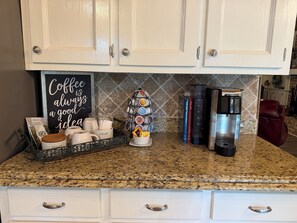 Una encimera de cocina con una estación de café, una cafetera y un letrero que dice 'Coffee is always a good idea'.
