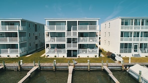 Una serie di edifici residenziali a tre piani con balconi, un molo e una piccola barca.