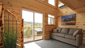 Un interno in legno con un divano, un quadro e una scala.