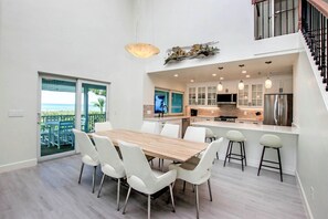 Enjoy ocean views from the open kitchen and dining area, featuring a balcony and modern appliances.