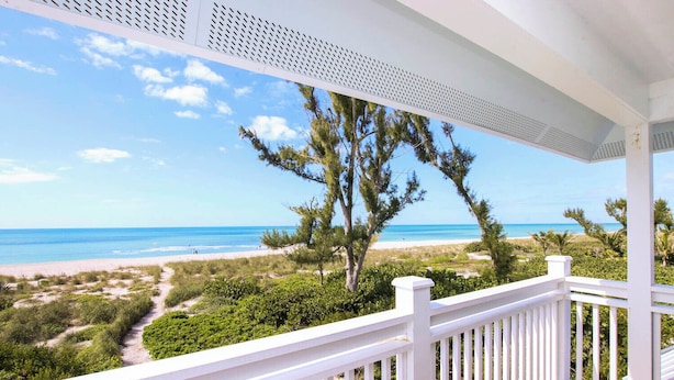 Ein überdachter Balkon mit Blick auf Strand und Meer.