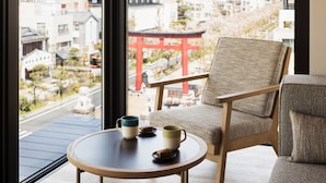 A room with a view of a cityscape, a traditional Japanese torii gate, and a table with two cups and a plate. - Hotel Metropolitan Kamakura (Kamakura)
