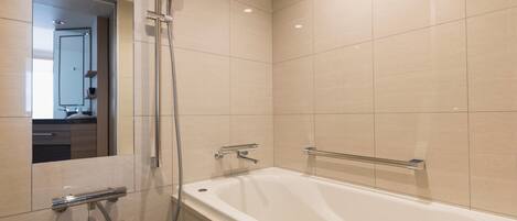 Un baño moderno con bañera, ducha y espejo.