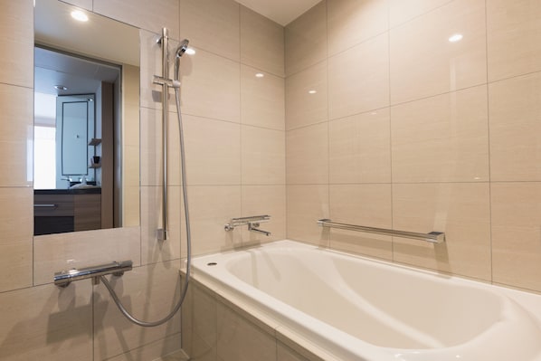A modern bathroom with a bathtub, a shower, and a mirror. - Hotel Metropolitan Kamakura (Kamakura)