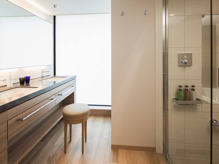 Une salle de bain moderne avec un meuble-lavabo en bois, une cabine de douche en verre et un grand miroir.