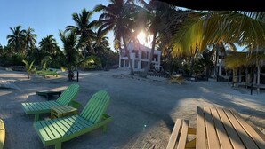 A beach with kayaks, lounge chairs, and a lifeguard tower.