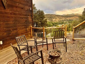 A wooden deck with outdoor seating and a fire pit.