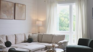 A modern living room with a sectional sofa, a round coffee table, and a ceiling fan.