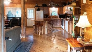 Ein rustikales Blockhaus-Interieur mit einer Holzespeisekammer, einer Küche und einem Wohnzimmer.