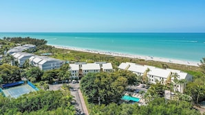 A resort with multiple buildings, a beach, and a swimming pool.