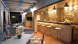 A modern kitchen with a stone backsplash, bar stools, and pendant lighting. - Boutique studio for 2pers. (109) (Malia)