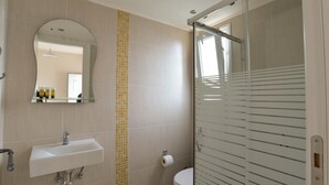 A bathroom with a white sink, a mirror, and a glass shower enclosure. - Boutique studio for 2pers. (109) (Malia)