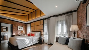 A modern hotel room with a large bed, a sofa, a desk, and a bathroom. - El Barrio Lanna (Chiang Mai)