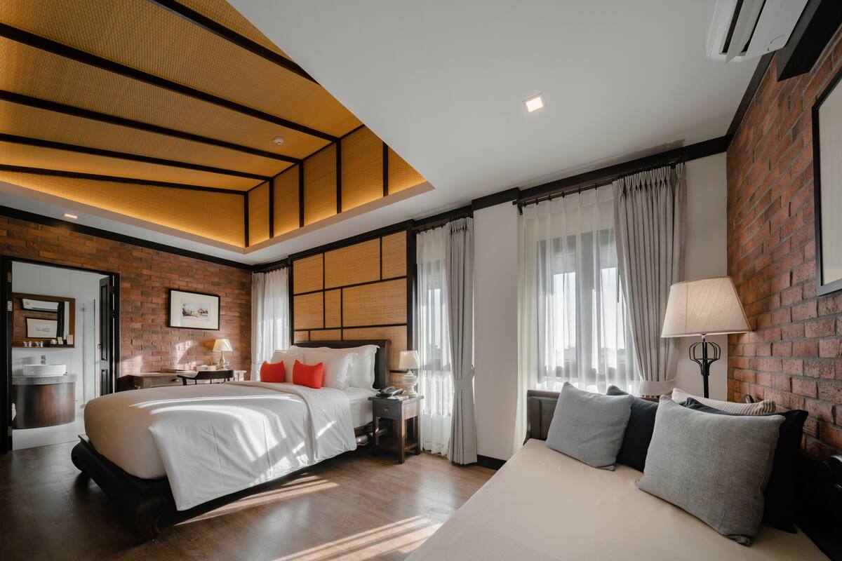 Een moderne hotelkamer met een groot bed, een slaapbank, een bureau en een badkamer.