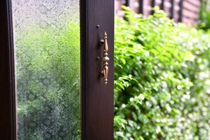 A door with a brass handle and a glass panel with a floral pattern. - El Barrio Lanna (Chiang Mai)